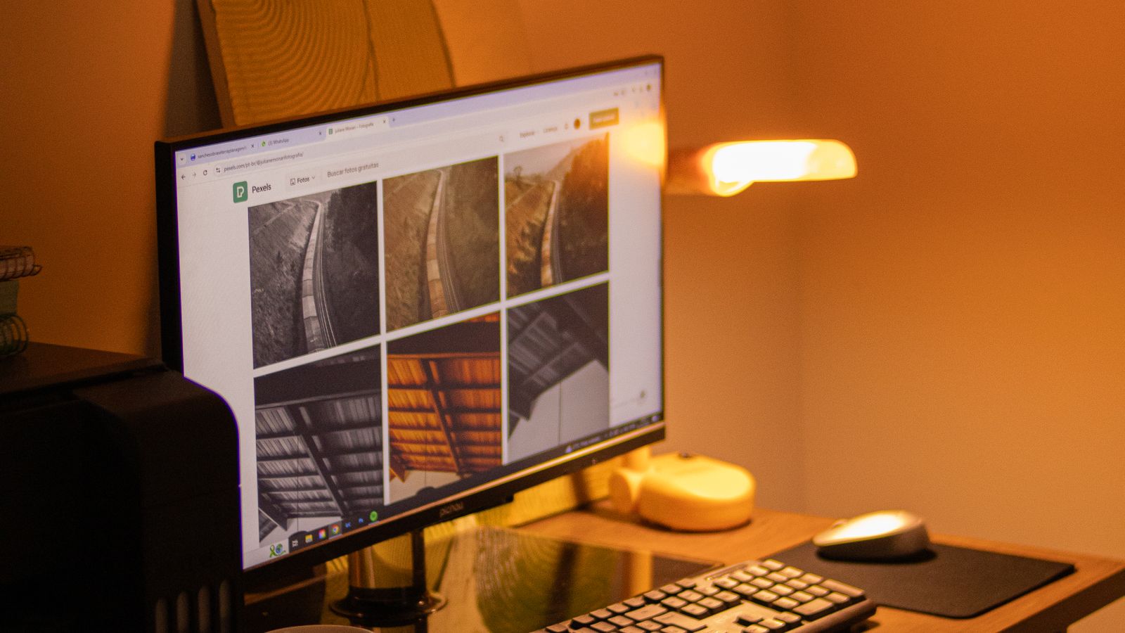 Escritorio de teletrabajo iluminado por una lámpara LED de luz cálida al anochecer