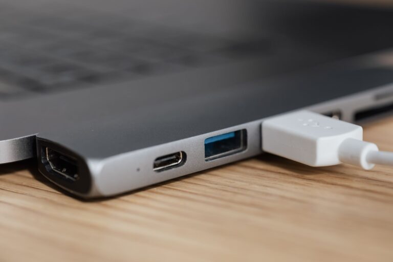 Hub USB-C multiconector conectado a un portátil sobre un escritorio de madera