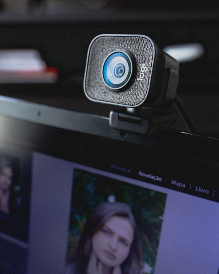 Webcam externa montada sobre la pantalla de un portátil en un escritorio de trabajo