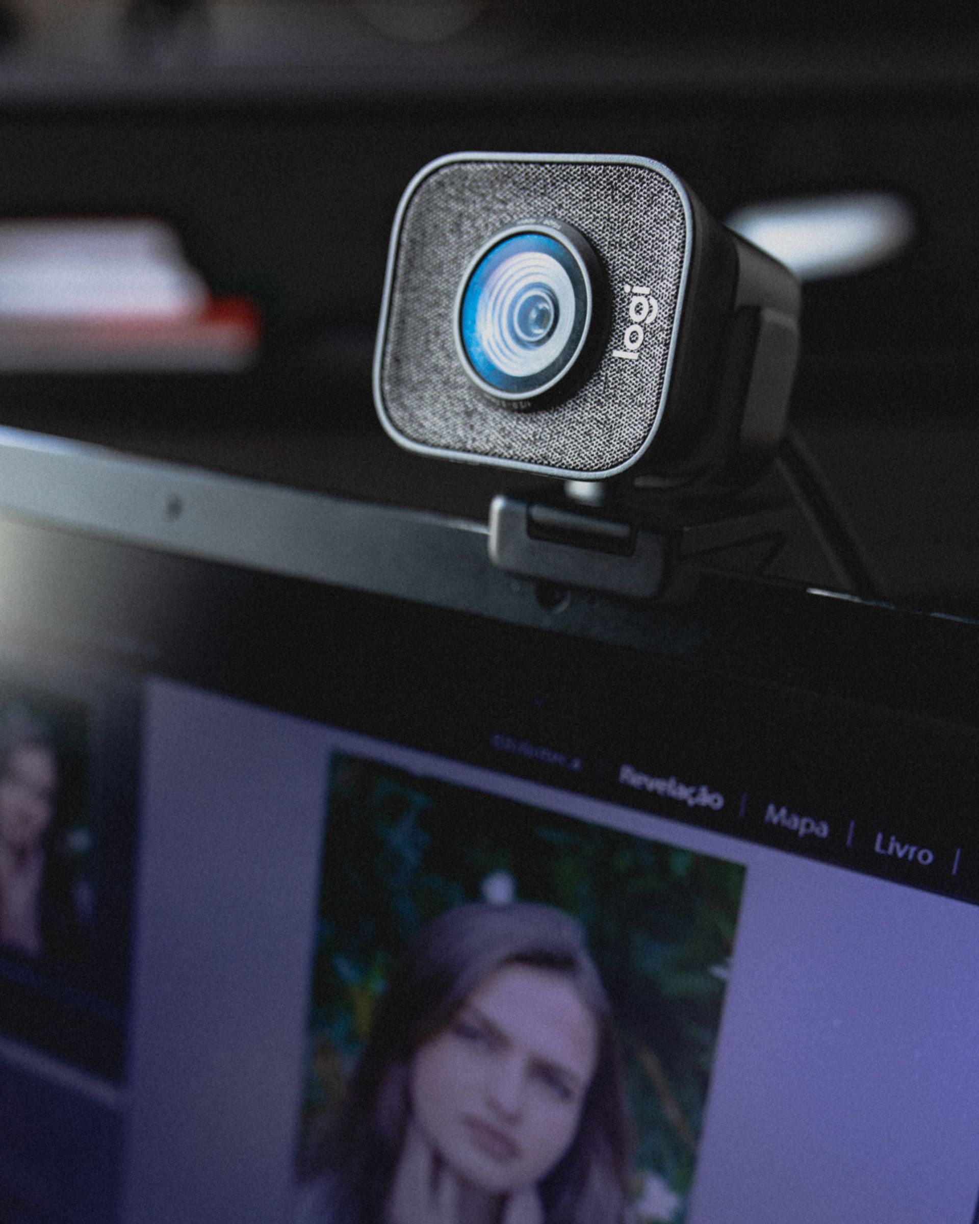 Webcam externa montada sobre la pantalla de un portátil en un escritorio de trabajo